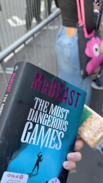 A wrapped Starbucks rice crispy treat held next to the cover of The Most Dangerous Games, on the line