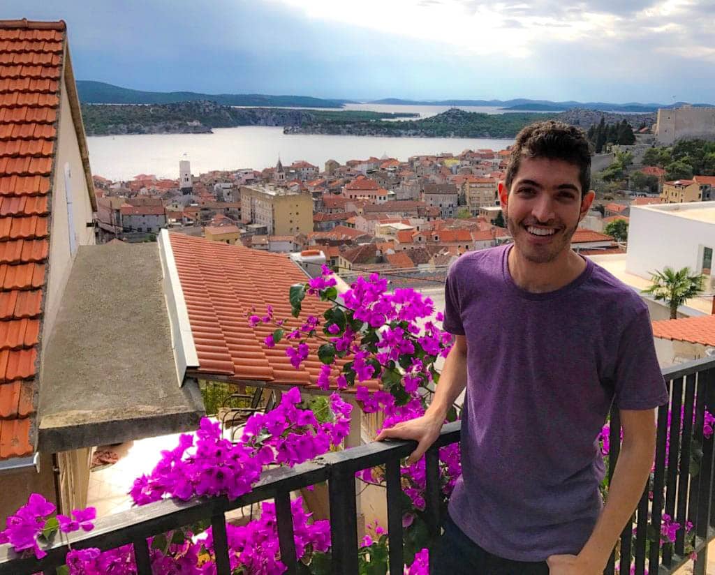 Rocky on a flower-lined balcony overlooking the water in Croatia