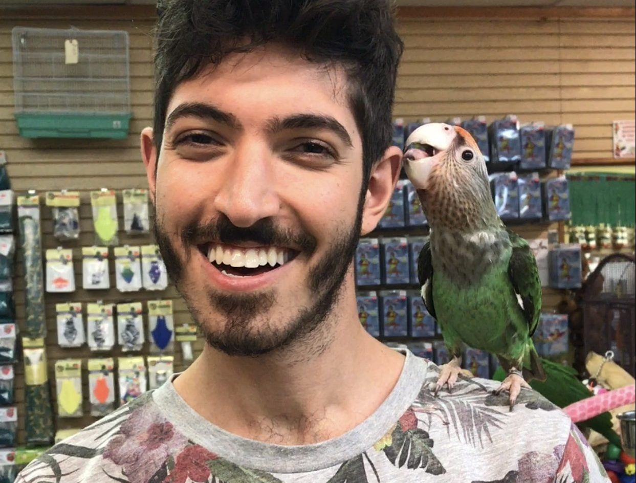 Rocky smiling with a parrot perched on his shoulder