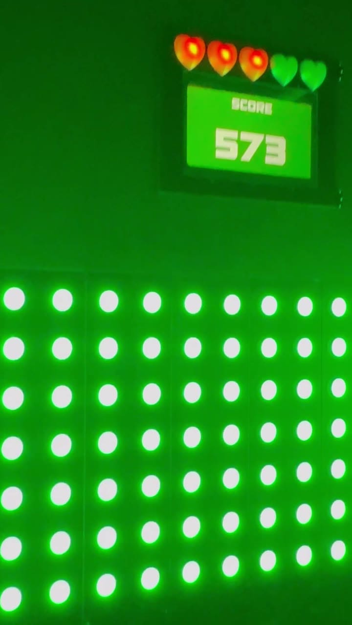 A green scoreboard reading 573 above a wall of light-up buttons