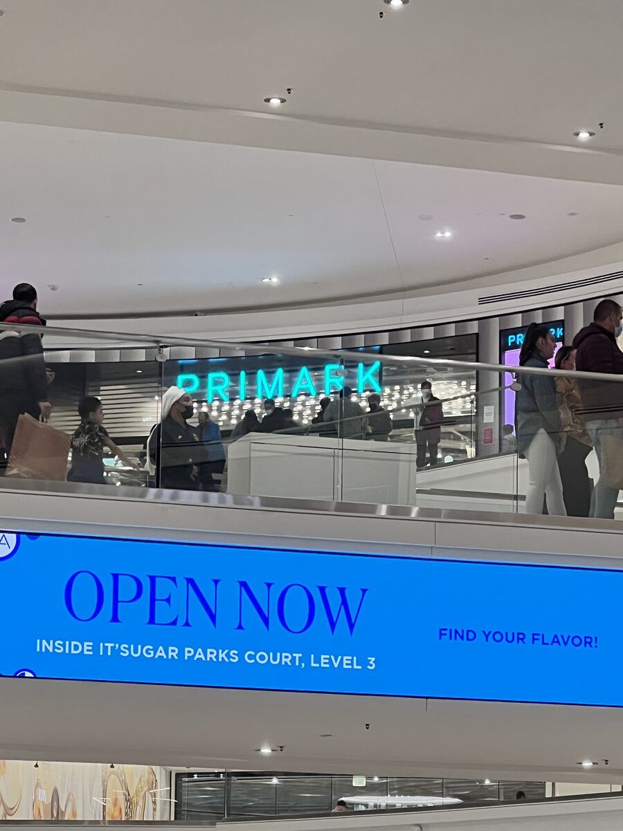 A Primark storefront beside a large blue billboard reading Inside IT SUGAR, Parks Court, Level 3