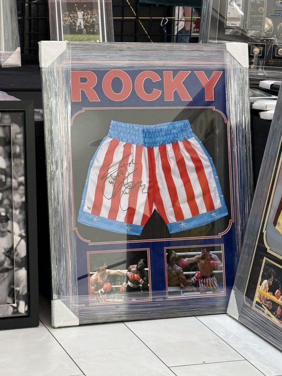 A framed pair of Rocky Balboa’s signed star-spangled boxing shorts under the word ROCKY