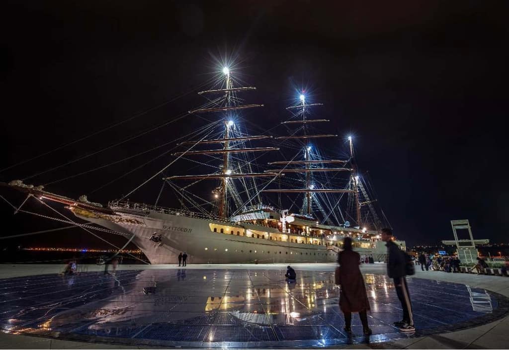 A long exposure at night on the Zadar waterfront, a lit ship behind