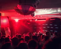 Red lights over a packed nightclub dance floor in Warsaw