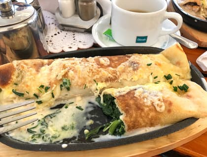 A spinach and cheese naleshniki crepe on a plate