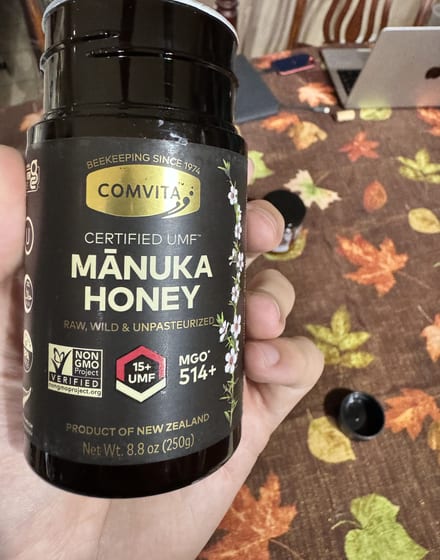 Holding the Comvita Manuka honey jar