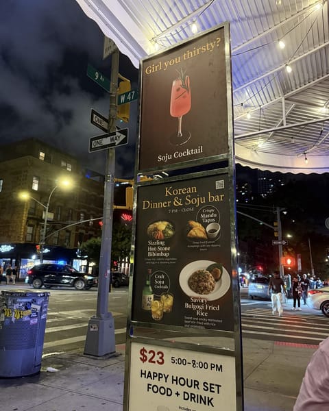 Sidewalk signs outside UT47 Kitchen and Bar at 9th Avenue and West 47th Street advertising soju cocktails and a Korean dinner and soju bar
