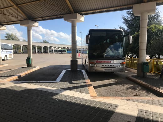 A coach waiting under the canopy at the bus terminal