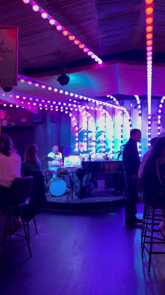 The band playing at The Friki Tiki, then a close-up of a cocktail on the bar