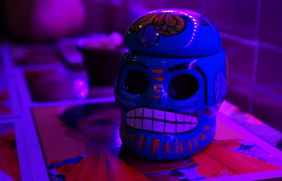 The blue sculpted calavera Rocky brought home from Cancun, lit from the side