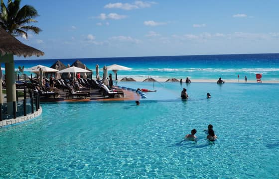 The resort infinity pool looking out at the Caribbean, palm trees along the edge