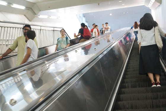 A Beijing subway sign reading please stand firm and hold the handrail