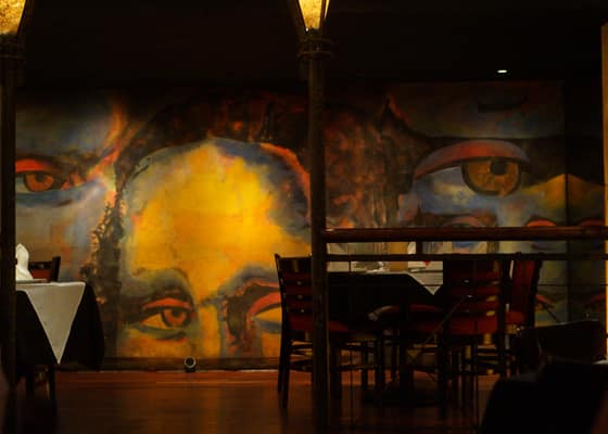 A huge painted face filling the wall behind the tables at La Madonna