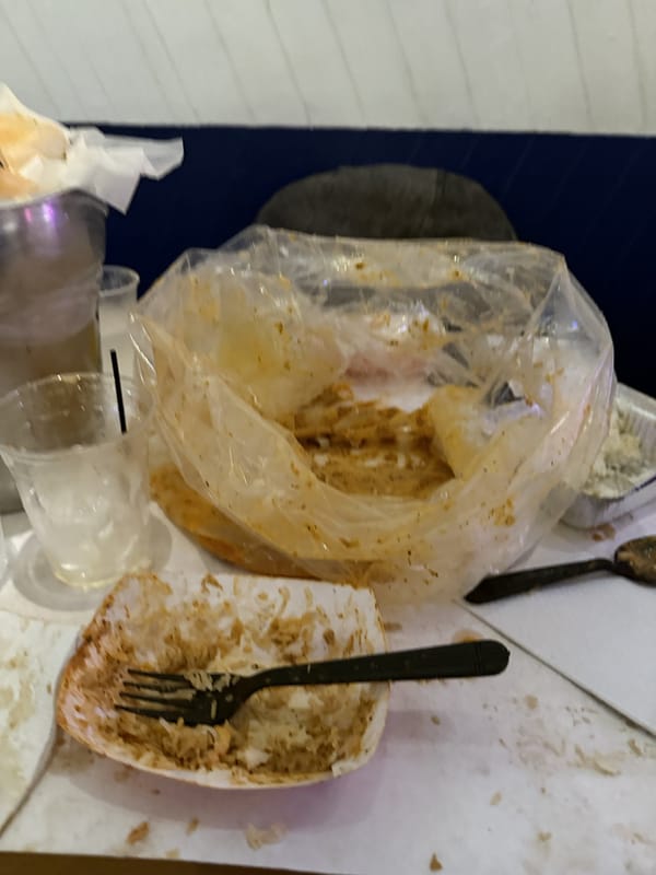 An emptied seafood boil bag and a fork on the table