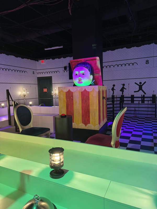 A striped carnival booth with lanterns and a checkerboard floor in the finale room