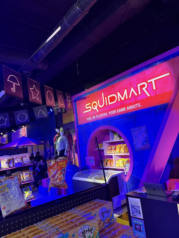 The Squid Mart merchandise stand under neon signs