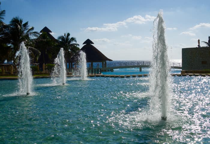 Tall fountains in the resort lagoon in daylight, Cancun