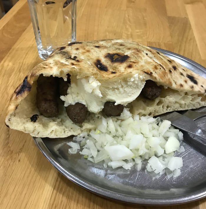 Ćevapi served with somun bread and onions in Sarajevo