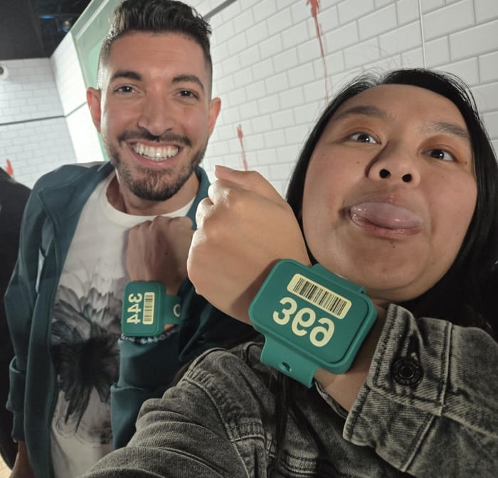 Rocky and Tracy holding up their teal player wristbands, numbers 344 and 369
