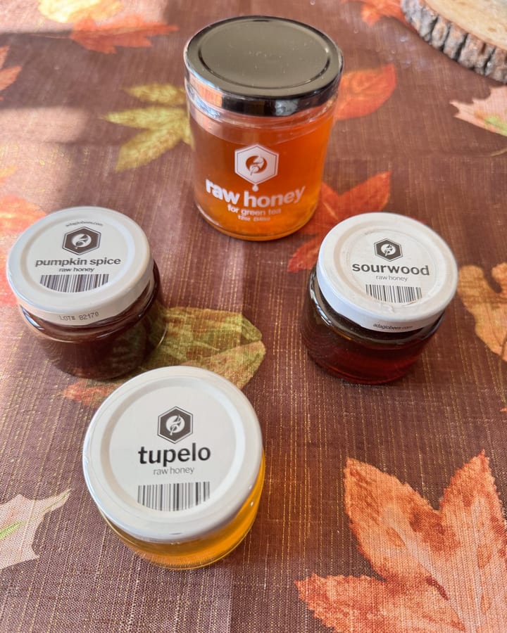 Four Adagio honey jars on a fall-leaf tablecloth: raw honey for green tea, tupelo, sourwood and pumpkin spice