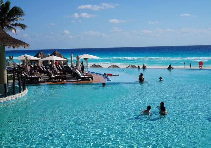 The resort infinity pool looking out at the Caribbean, palm trees along the edge