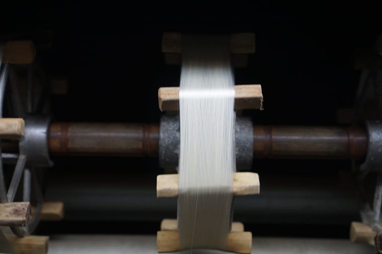 A cocoon being unwound into thread