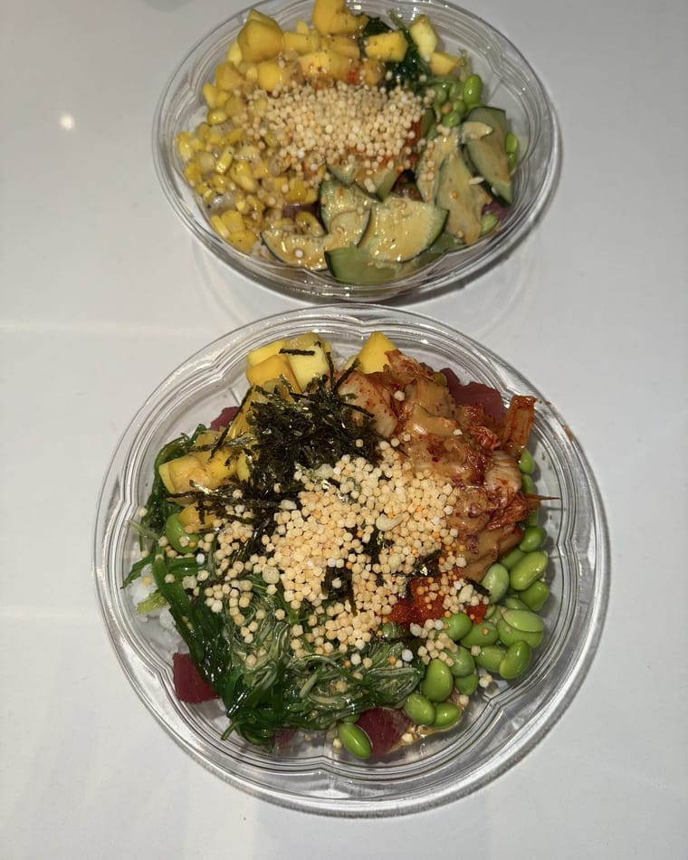 Two poke bowls from above, one with mango and cucumber, the other with tuna, seaweed salad, edamame and mango, both sprinkled with crunchy toppings