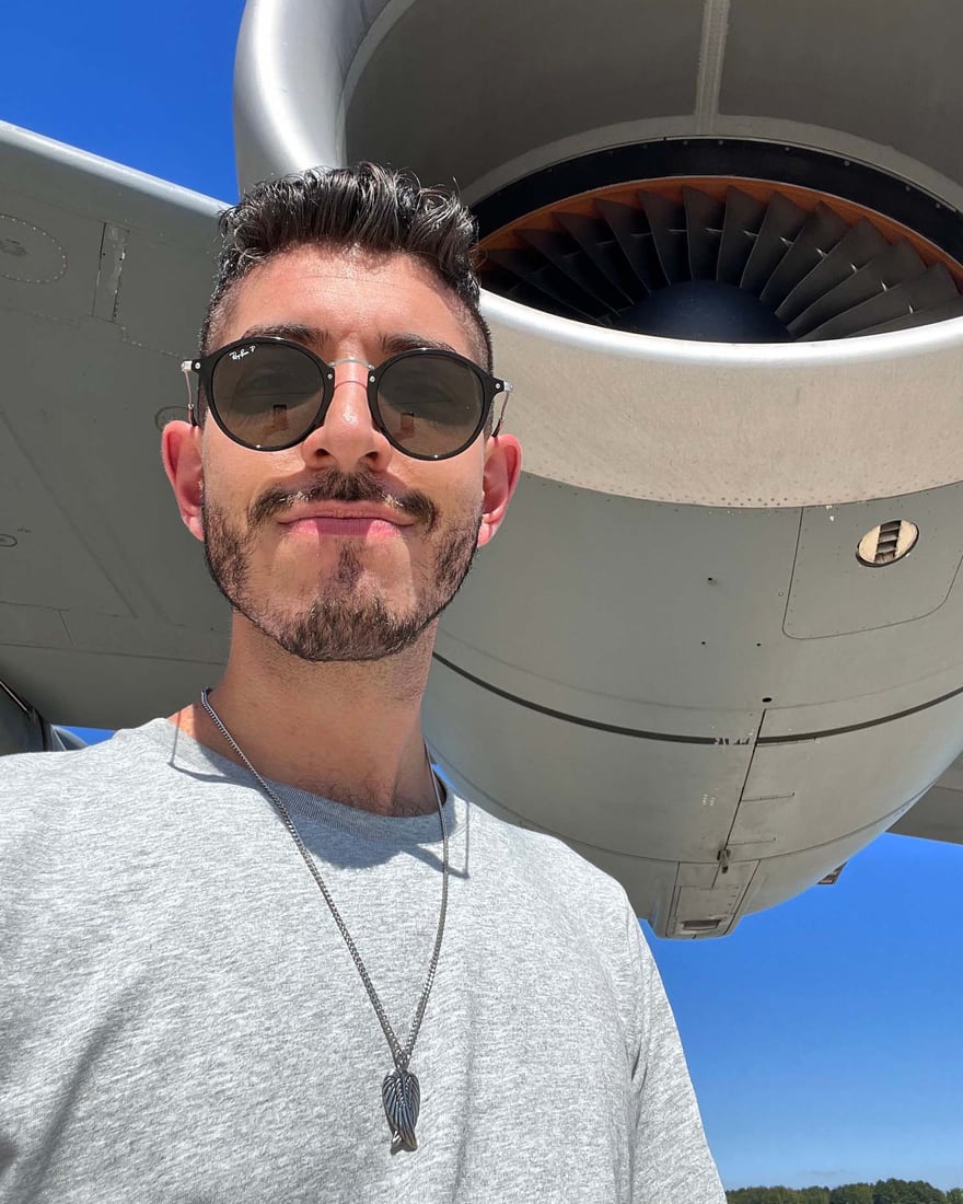 Rocky Trifari standing in front of an airplane, ready to travel