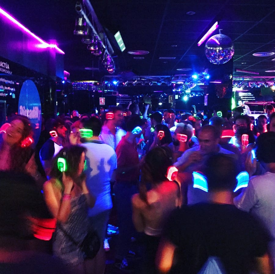 Headphones lit up red, green and blue on a dance floor