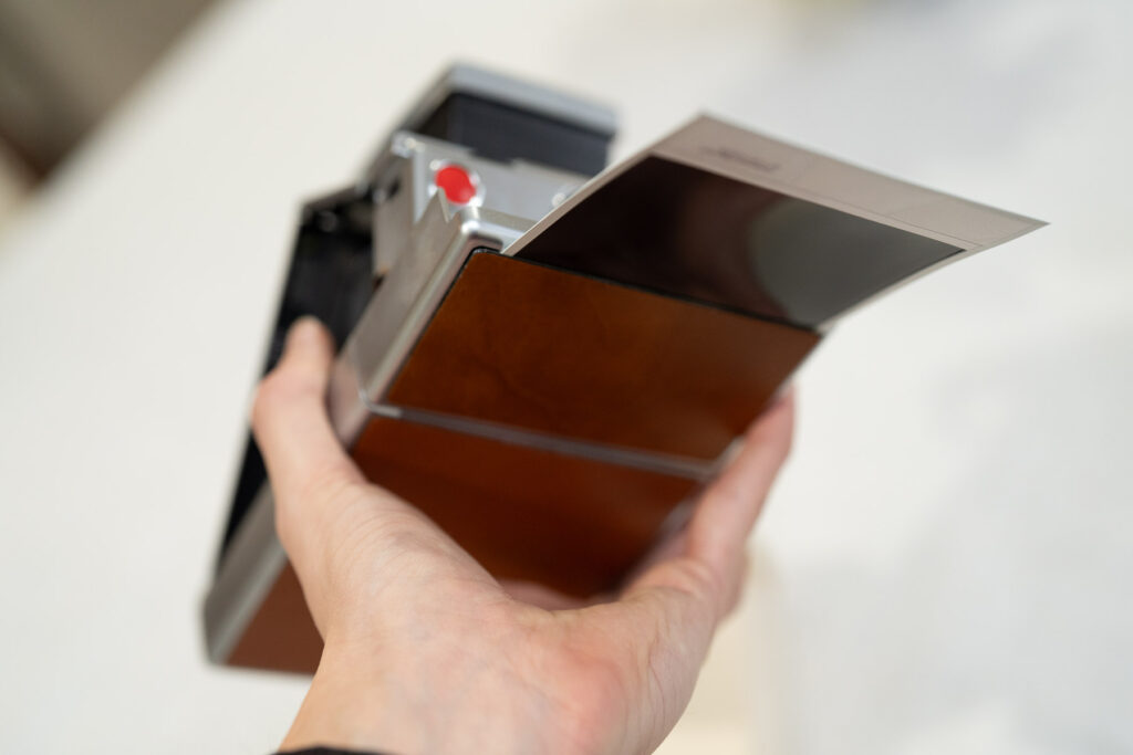 Film ejects under the Polaroid SX-70 Land Camera
